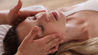 Woman receiving calming therapy session and head massage